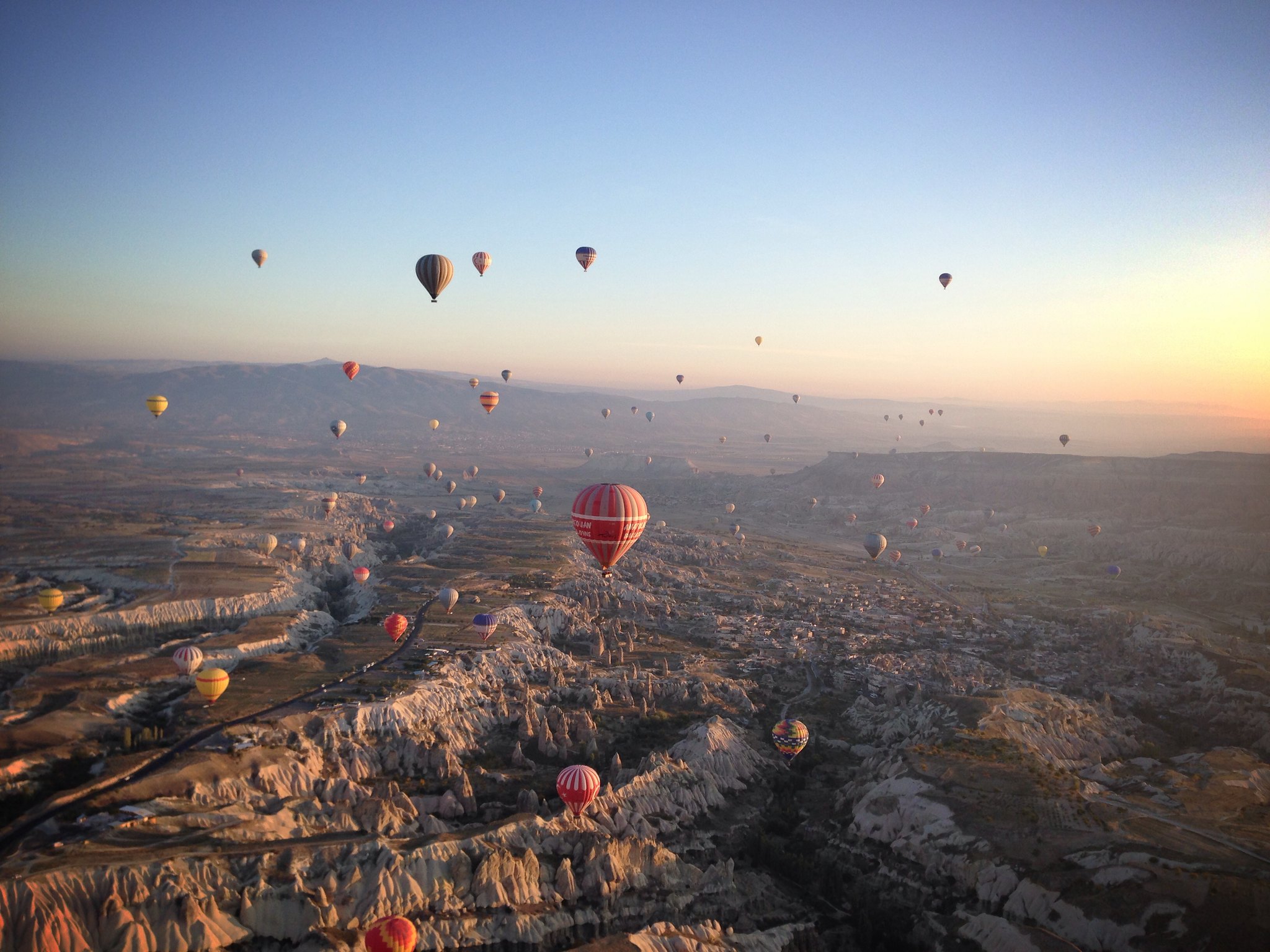 Hot air balloons flying over 'fairy chimney' rock formations in Cappadocia